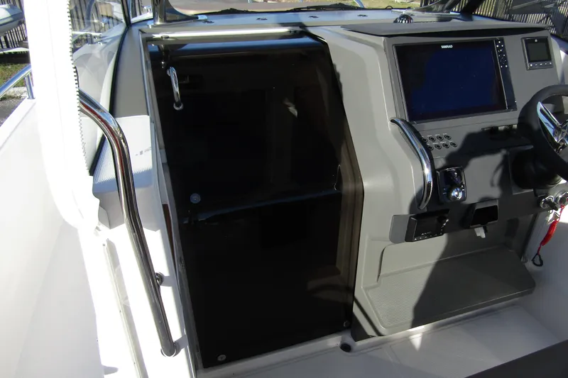 Slide: The Image of Control panel of 2025 Nimbus Tender 9 boat with steering wheel and navigation screen. - 21