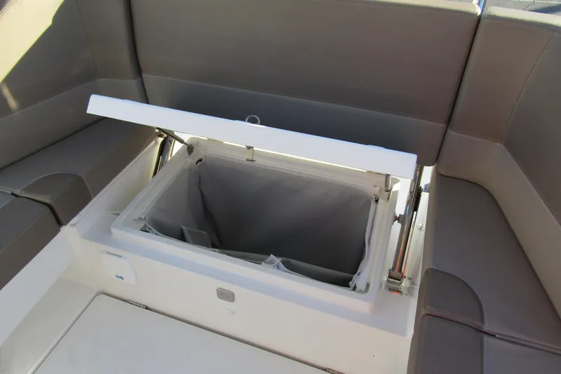 Slide: The Image of 2025 Nimbus Tender 9 boat storage compartment with open lid and cushioned seating. - 29
