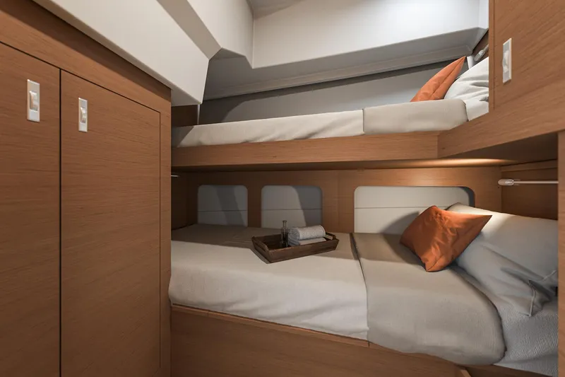 Slide: The Image of 2026 Beneteau Swift Trawler 37 FLY cabin with cozy bunk beds and wooden interior. - 14
