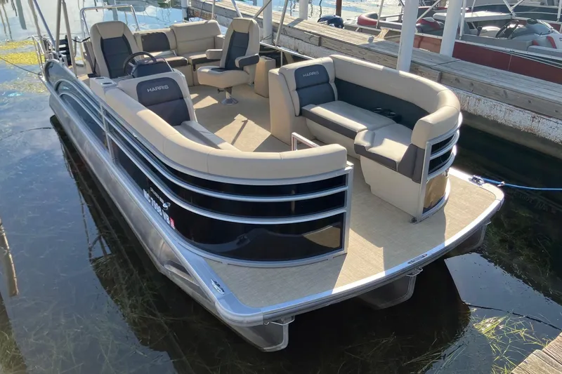 The Image of 2025 Harris Cruiser 230 pontoon boat docked, featuring spacious seating and modern design. - 0