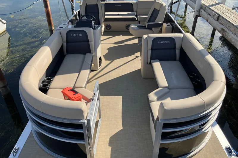 Slide: The Image of 2025 Harris Cruiser 230 pontoon boat with spacious seating and modern design. - 2