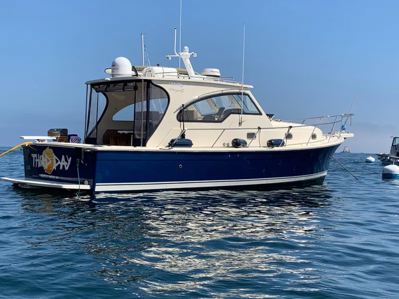 The Image of 2005 Mainship 34 Pilot Sedan Rum Runner II boat on calm water. - 0