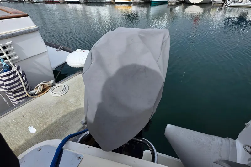 Slide: The Image of Covered outboard motor on a 2005 Mainship 34 Pilot Sedan Rum Runner II at a marina. - 11