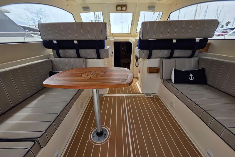 Slide: The Image of Interior of 2005 Mainship 34 Pilot Sedan Rum Runner II with striped seating and wooden table. - 12