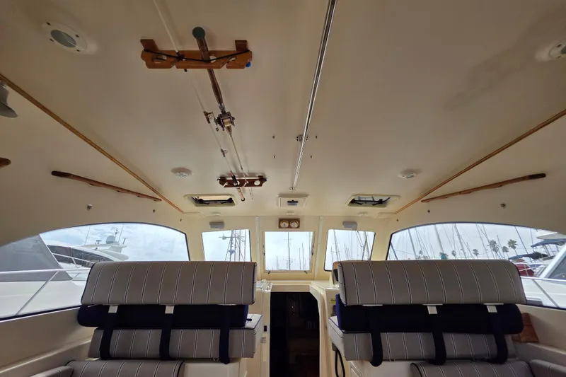 Slide: The Image of Interior of 2005 Mainship 34 Pilot Sedan Rum Runner II with striped seating and large windows. - 13