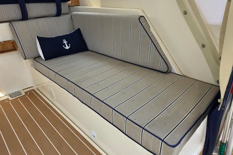 Slide: The Image of 2005 Mainship 34 Pilot Sedan Rum Runner II interior with striped seating and anchor pillow. - 14
