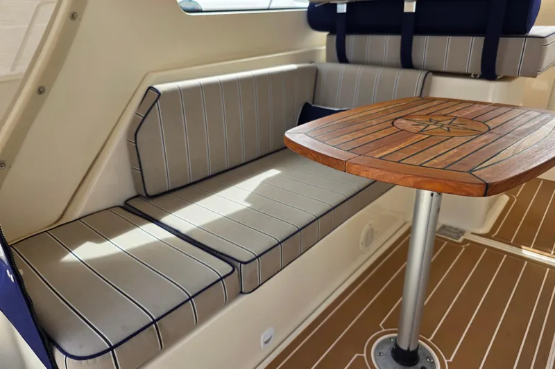 Slide: The Image of 2005 Mainship 34 Pilot Sedan Rum Runner II interior with striped seating and wooden table. - 15