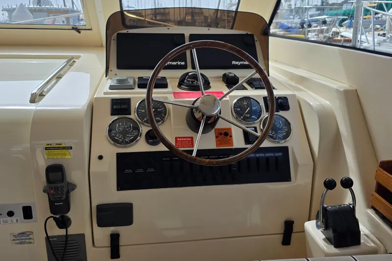 Slide: The Image of 2005 Mainship 34 Pilot Sedan Rum Runner II helm with steering wheel and control panel. - 18