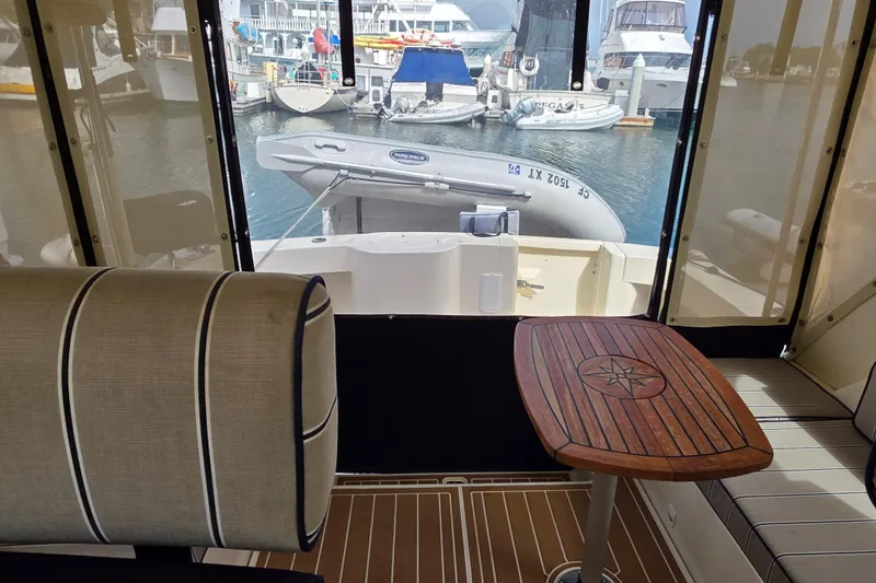 Slide: The Image of Interior view of 2005 Mainship 34 Pilot Sedan Rum Runner II, featuring seating and a wooden table. - 21