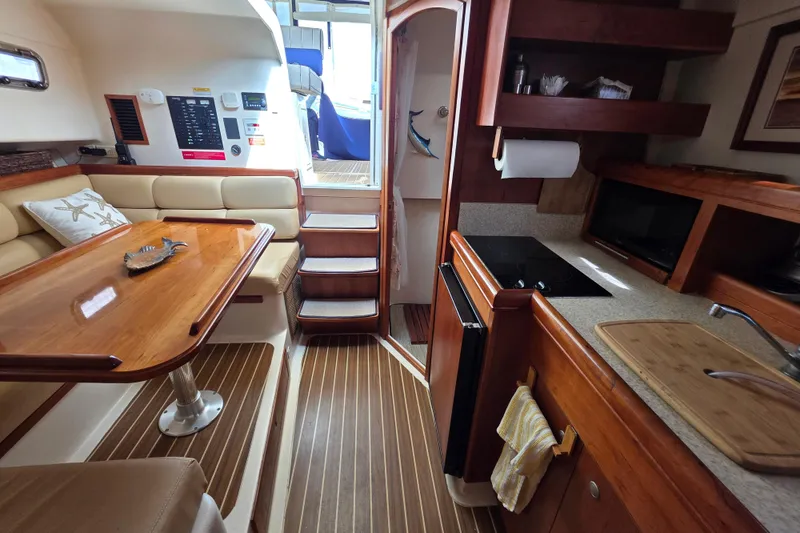Slide: The Image of 2005 Mainship 34 Pilot Sedan Rum Runner II interior with kitchen and dining area. - 25