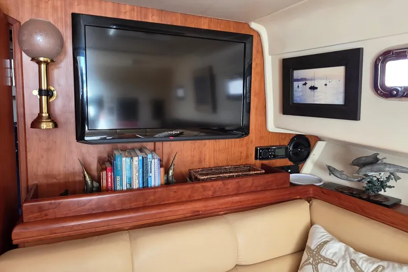 Slide: The Image of Interior of 2005 Mainship 34 Pilot Sedan with TV, books, and nautical decor. - 28