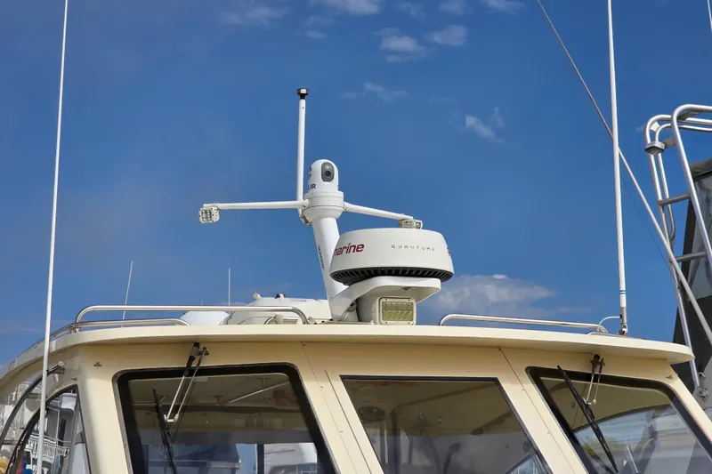 Slide: The Image of 2005 Mainship 34 Pilot Sedan Rum Runner II with radar equipment against blue sky. - 3