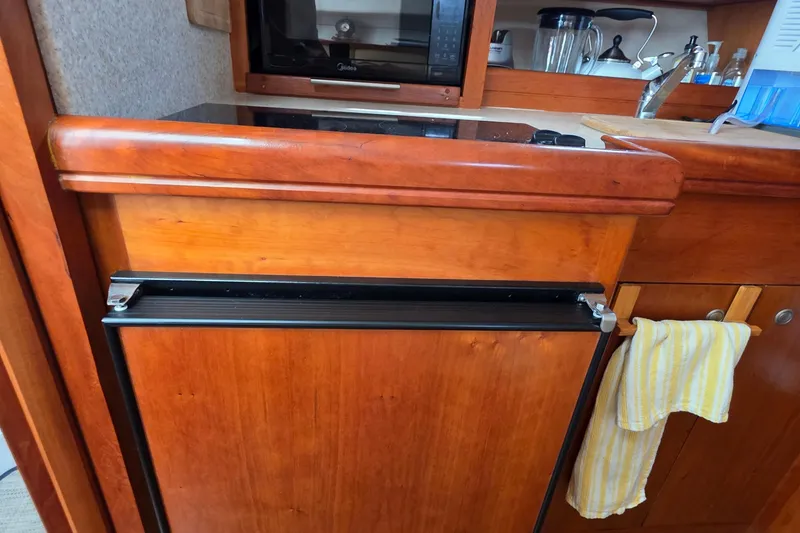 Slide: The Image of 2005 Mainship 34 Pilot Sedan Rum Runner II galley with wood cabinetry and appliances. - 30