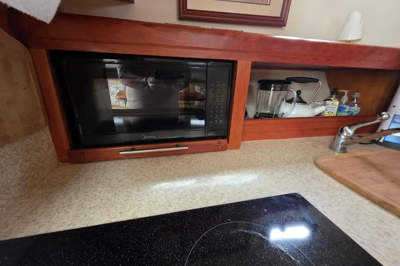 Slide: The Image of 2005 Mainship 34 Pilot Sedan Rum Runner II galley with microwave, blender, and sink. - 32