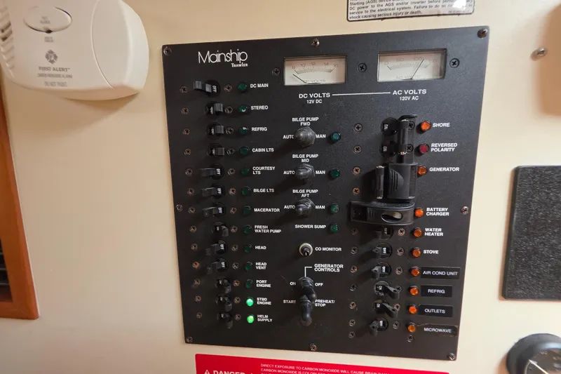 Slide: The Image of Control panel of 2005 Mainship 34 Pilot Sedan Rum Runner II boat, featuring various switches and indicators. - 35