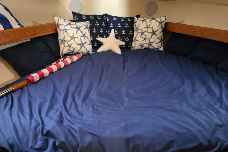 Slide: The Image of Cozy cabin interior of 2005 Mainship 34 Pilot Sedan Rum Runner II with nautical-themed pillows. - 36