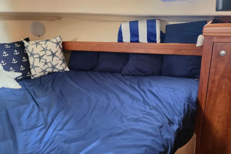 Slide: The Image of Cozy cabin bed with nautical-themed pillows on 2005 Mainship 34 Pilot Sedan Rum Runner II. - 37