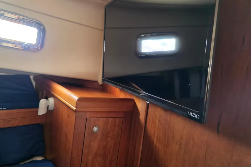 Slide: The Image of Interior of 2005 Mainship 34 Pilot Sedan Rum Runner II with TV and wooden cabinetry. - 38