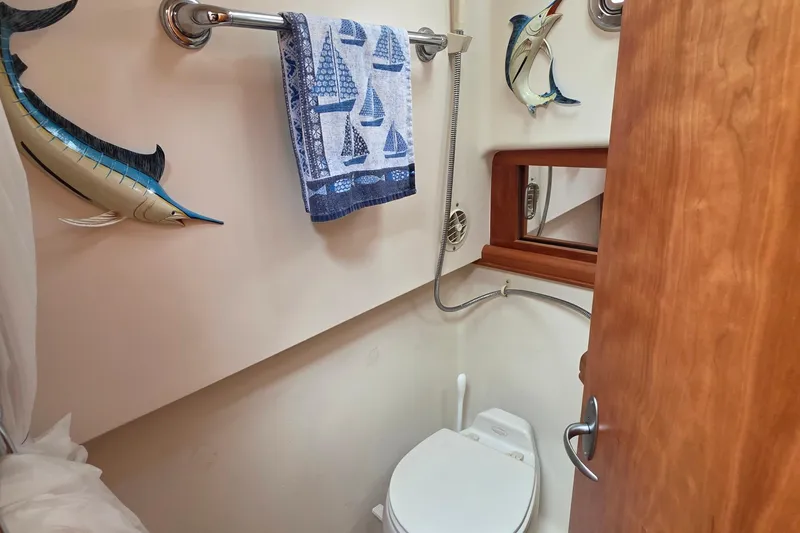 Slide: The Image of 2005 Mainship 34 Pilot Sedan bathroom with nautical decor and towel rack. - 39