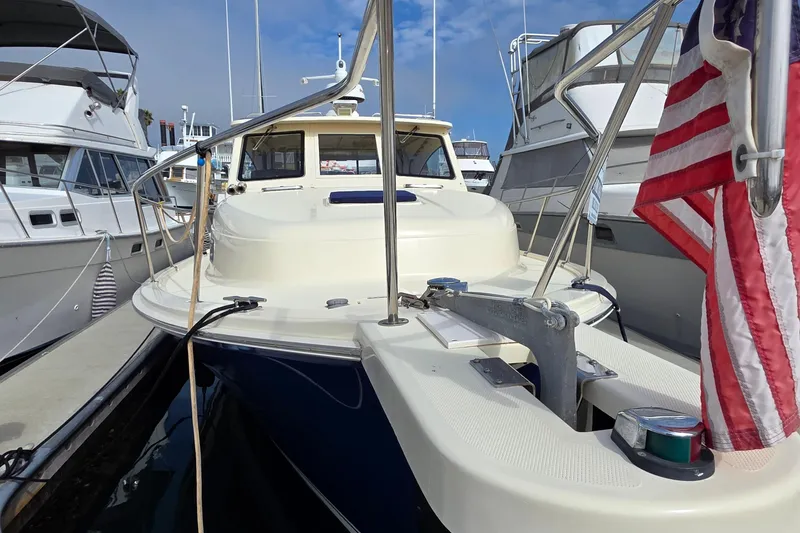 Slide: The Image of 2005 Mainship 34 Pilot Sedan Rum Runner II docked, featuring American flag and anchor. - 47