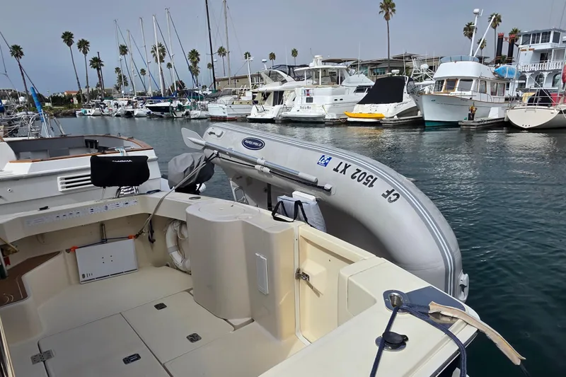 Slide: The Image of 2005 Mainship 34 Pilot Sedan Rum Runner II docked in a marina with inflatable boat. - 5