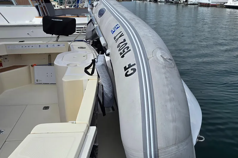 Slide: The Image of 2005 Mainship 34 Pilot Sedan Rum Runner II with inflatable boat docked at marina. - 6
