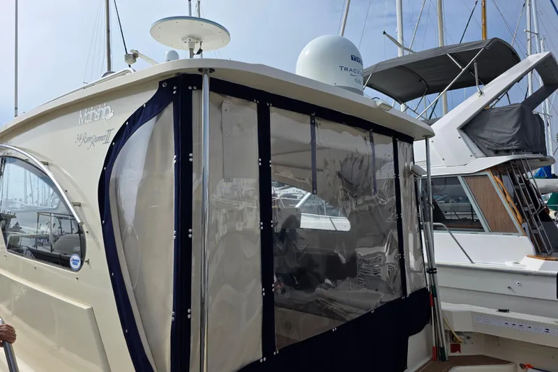 Slide: The Image of 2005 Mainship 34 Pilot Sedan Rum Runner II docked at marina, featuring enclosed cabin. - 7