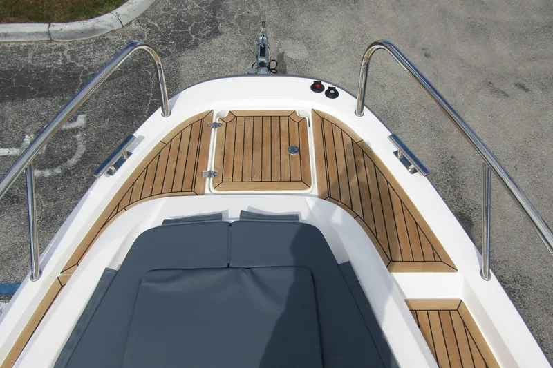 Slide: The Image of 2025 Nimbus Weekender 9 boat deck with teak flooring and cushioned seating. - 12