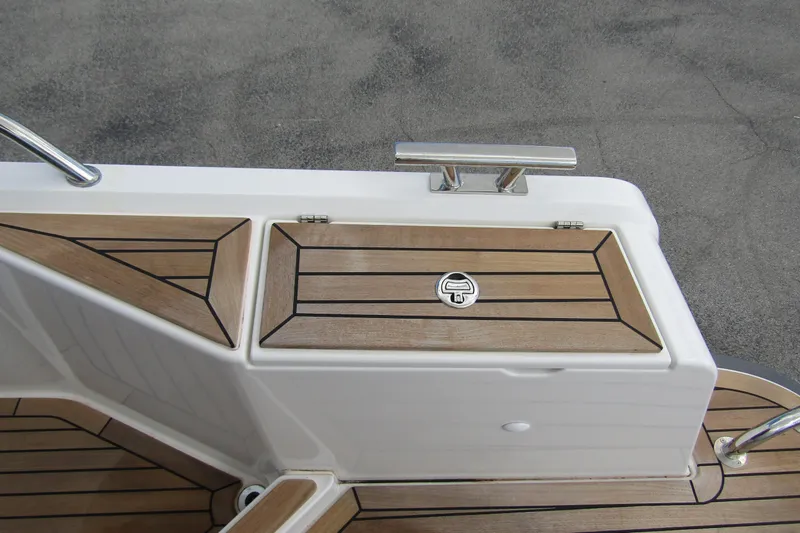 Slide: The Image of Teak deck detail on 2025 Nimbus Weekender 9 boat, featuring sleek design and stainless steel cleat. - 49