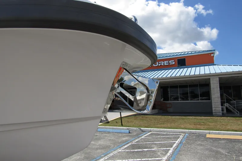 Slide: The Image of 2025 Nimbus Weekender 9 boat bow with anchor, parked near a building under a blue sky. - 8