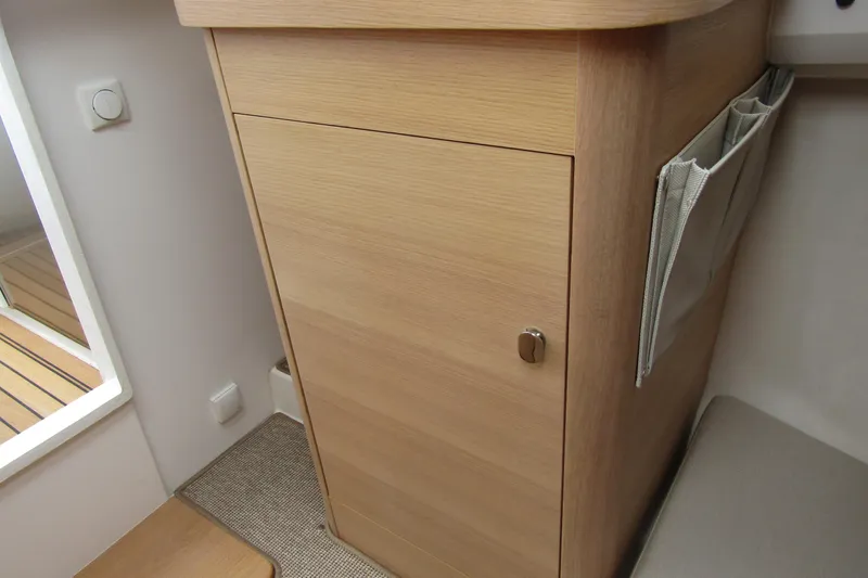 Slide: The Image of Wooden cabinet interior of 2025 Nimbus Weekender 9 boat, featuring sleek design and storage pocket. - 28