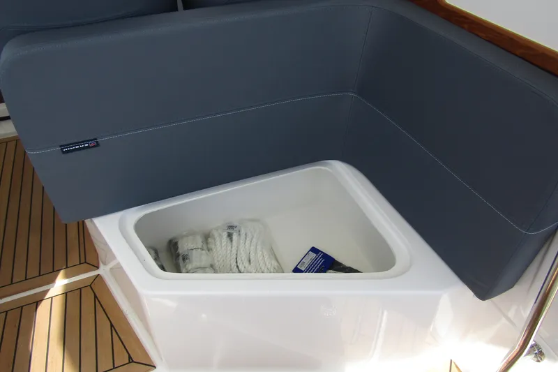 Slide: The Image of Storage compartment on Nimbus Weekender 9 boat, featuring cushioned seating and wooden flooring. - 43