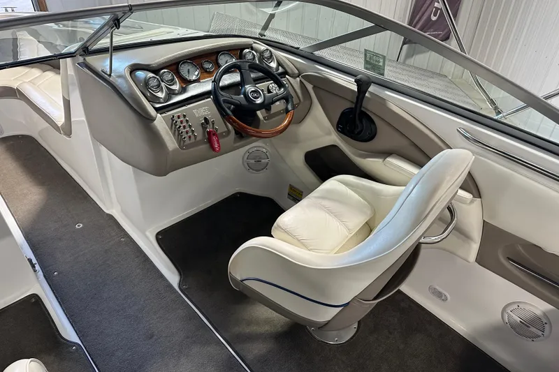 Slide: The Image of Interior of a 2006 Cobalt 220 boat featuring a sleek dashboard and comfortable seating. - 11