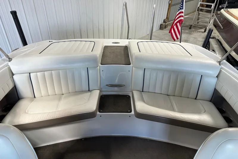 Slide: The Image of 2006 Cobalt 220 boat interior with white leather seating and American flag. - 13