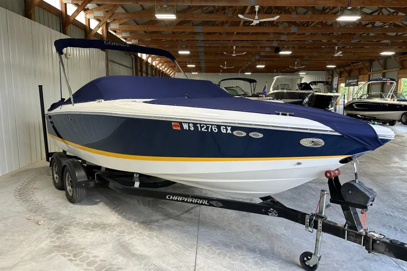 Slide: The Image of 2006 Cobalt 220 boat with blue cover on trailer in indoor storage. - 8