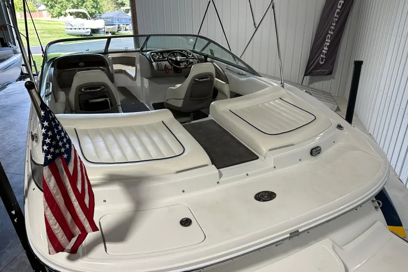 Slide: The Image of 2006 Cobalt 220 boat with American flag, white interior, and sleek design in a garage setting. - 9