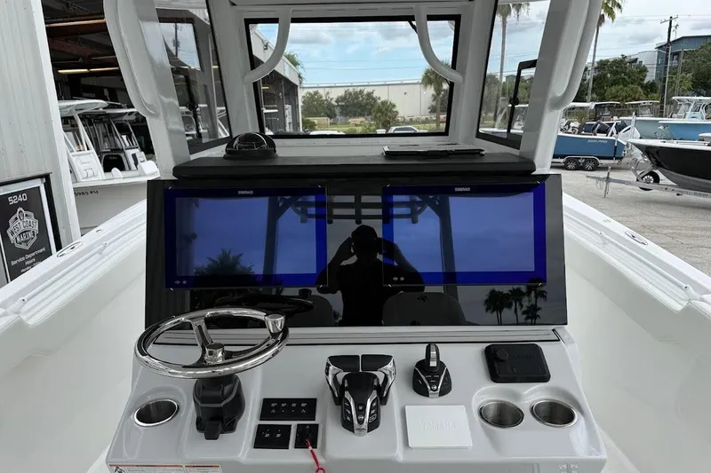 Slide: The Image of 2026 Sea Pro 322 Offshore helm with dual displays, steering wheel, and control panel. - 13