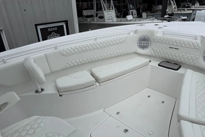 Slide: The Image of 2026 Sea Pro 322 Offshore boat interior with white cushioned seating and speaker system. - 21