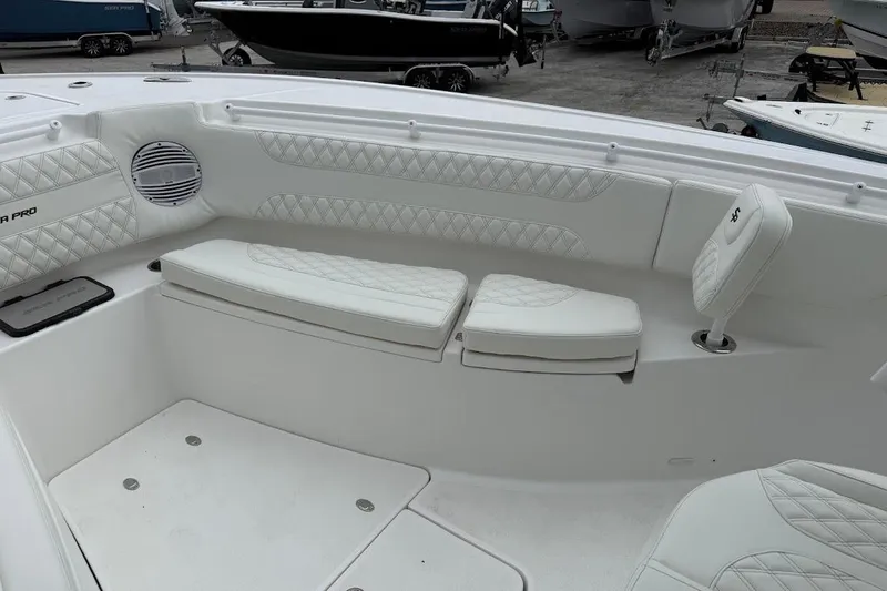 Slide: The Image of 2026 Sea Pro 322 Offshore boat interior with white cushioned seating and speaker. - 22