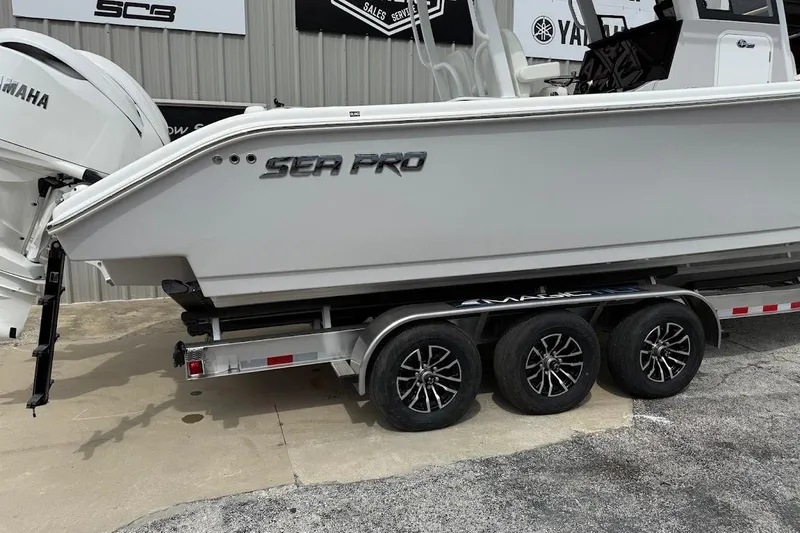 Slide: The Image of 2026 Sea Pro 322 Offshore boat on trailer, featuring Yamaha engines, parked outside dealership. - 5