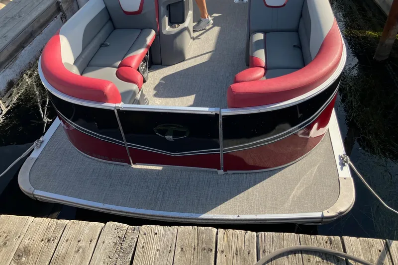 Slide: The Image of 2023 Tahoe Pontoon Cascade Platinum Versatile Rear Bench 23' docked, featuring red and gray seating. - 6