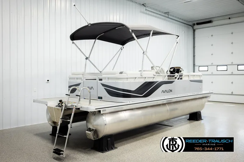 Slide: The Image of 2026 Avalon VLS QL pontoon boat in a showroom with canopy and ladder. - 6