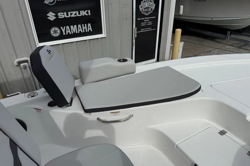 Slide: The Image of 2026 Sea Pro 230 Bay boat interior with gray seating, near Suzuki and Yamaha signage. - 17