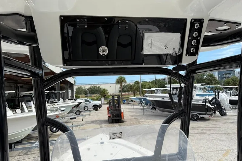 Slide: The Image of 2026 Sea Pro 230 Bay boat console with storage and controls, docked at a marina. - 21