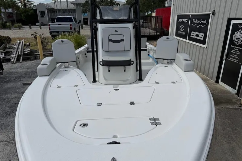 Slide: The Image of 2026 Sea Pro 230 Bay boat, white deck, docked near a marine shop. - 4