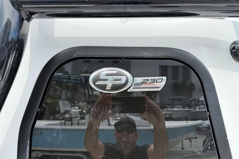 Slide: The Image of 2026 Sea Pro 230 Bay boat emblem with reflection of person taking photo. - 8