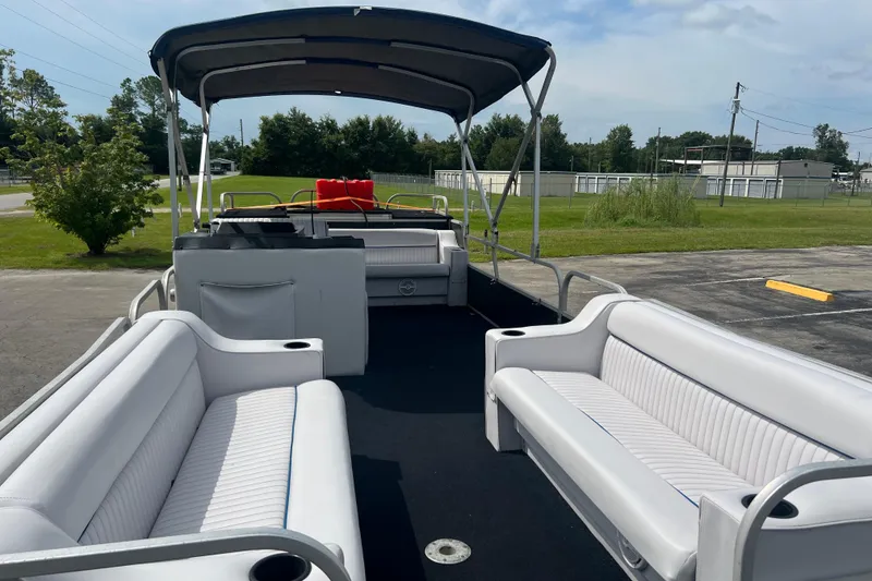 Slide: The Image of Pontoon boat interior with white seating, Spectrum 24 Cruise, 1991 model, parked outdoors. - 9