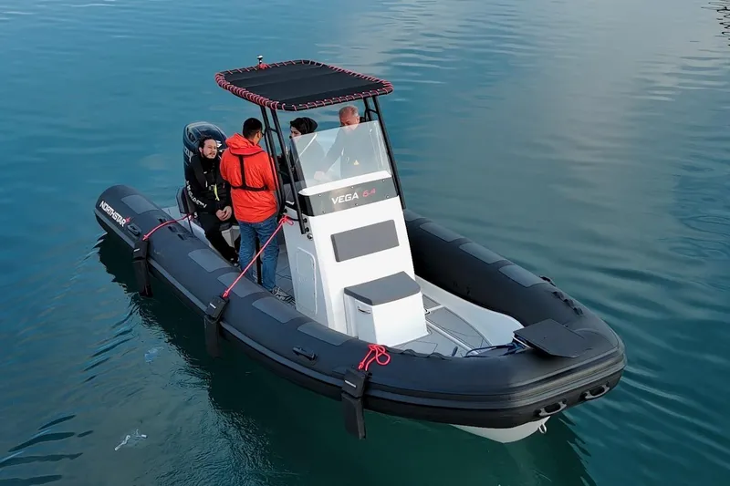 Slide: The Image of 2026 Northstar VEGA 6.4 boat on water with passengers, featuring sleek design and modern features. - 0