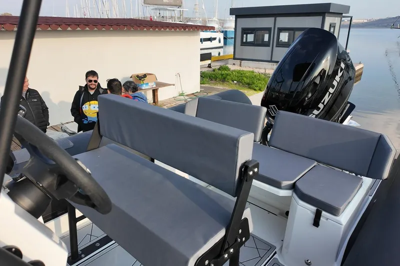 Slide: The Image of 2026 Northstar VEGA 6.4 boat with Suzuki engine, docked near a marina. - 12