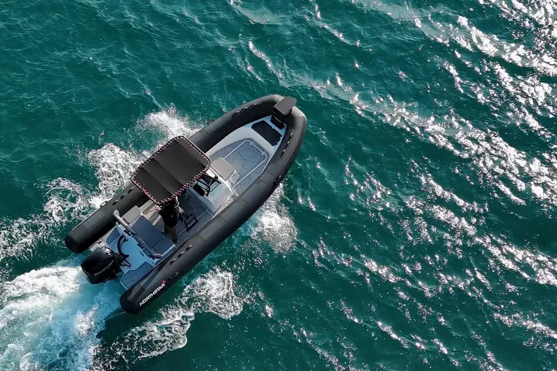 Slide: The Image of Aerial view of 2026 Northstar VEGA 6.4 boat cruising on turquoise water. - 2